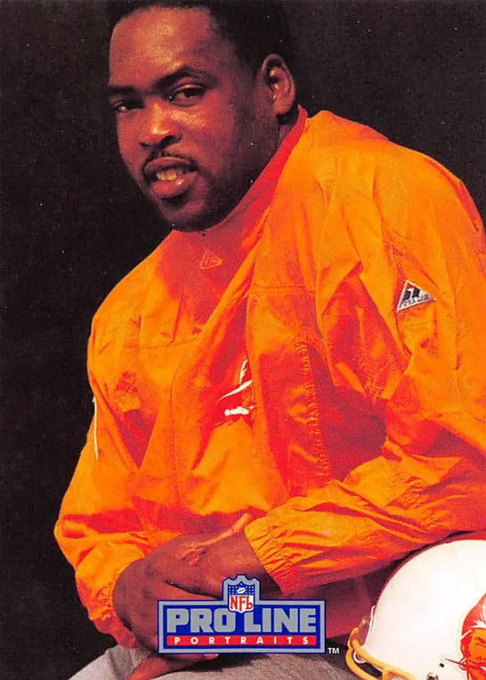 Person in bright orange NFL jacket showcasing Broderick Thomas Tampa Bay football card