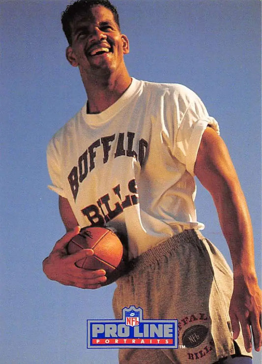 Person in Buffalo Bills t-shirt holds a football beside Andre Reed Pro Line Portraits card