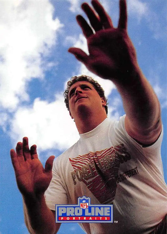 Person in white t-shirt reaching upward against sky, featured in Harris Barton card