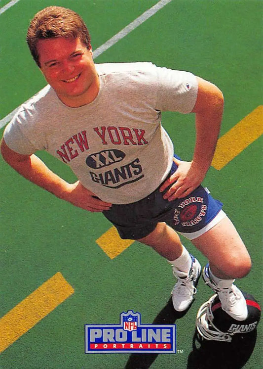 Person in New York Giants gear stretches on a football field near Bart Oates Pro Line card