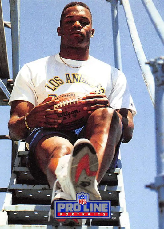 Athlete in white Los Angeles t-shirt with football, showcasing Roman Phifer football card