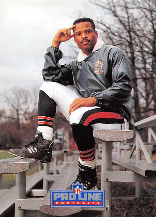 Shaun Gayle sitting on bleachers in a gray sweatshirt and striped socks with a football