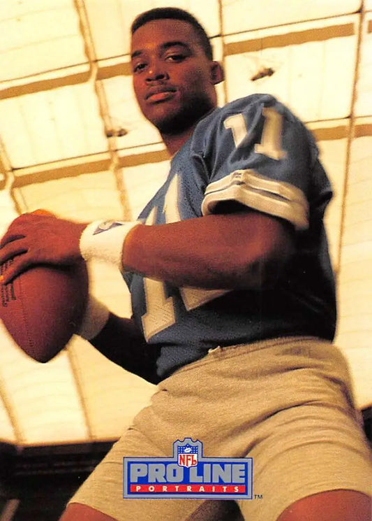 Football player in blue jersey holding football on Andre Ware Detroit Lions card