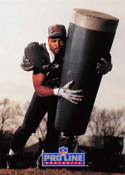 Football player in black uniform practicing with dummy, featuring John Roper, Chicago Bears
