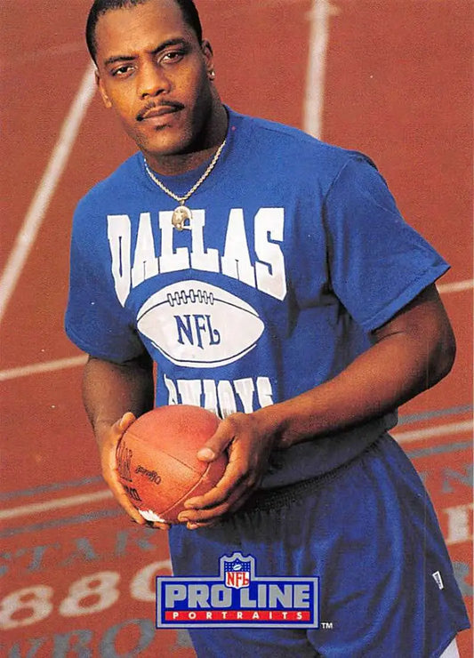 Issiac Holt in a blue Dallas Cowboys t-shirt holding a football for a football card