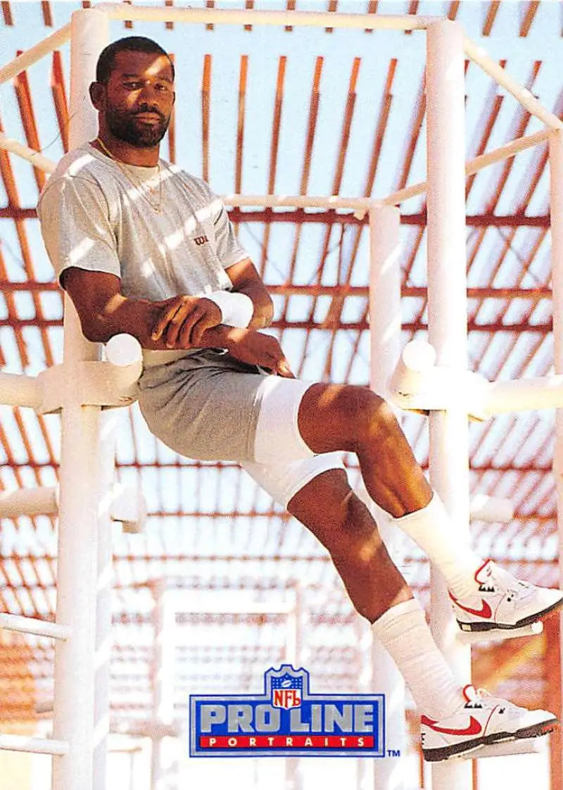 Football player in white attire on structure, featured in Pro Line Portraits J.T. Smith card