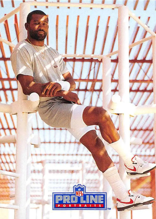 Football player in white attire on structure, featured in Pro Line Portraits J.T. Smith card