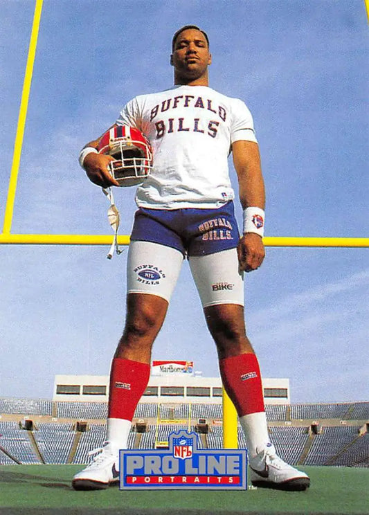 Cornelius Bennett in a Buffalo Bills shirt holding a football for Pro Line Portraits