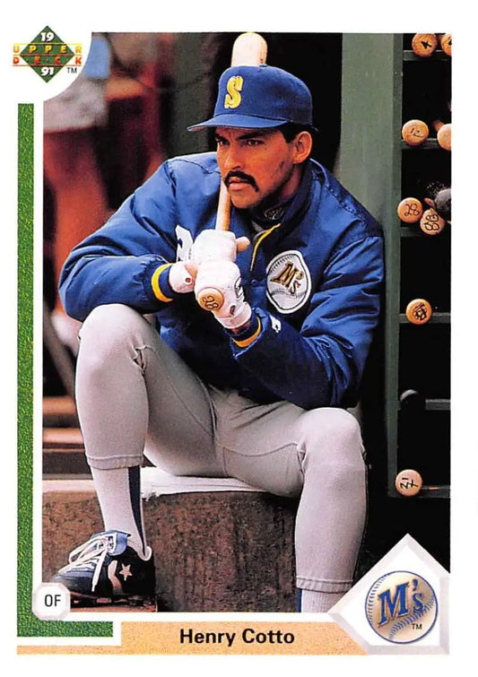 Baseball player Henry Cotto in Seattle Mariners uniform crouches in dugout