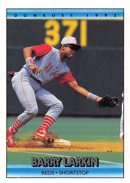 Barry Larkin making a play on this Cincinnati Reds baseball card from 1992 Donruss
