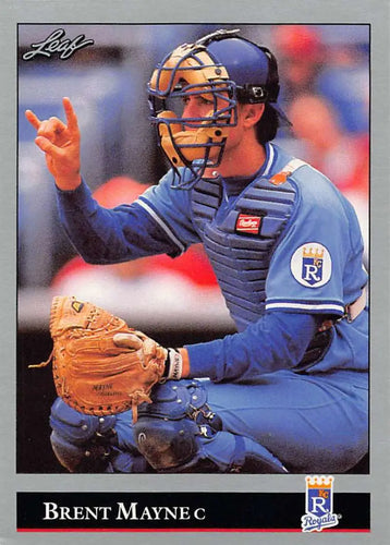 Baseball catcher in Kansas City Royals uniform signaling to teammates with protective gear