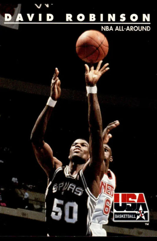 Basketball player in black Spurs jersey reaching for ball featured on USA Basketball card