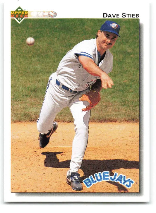 Baseball player in Toronto Blue Jays uniform delivering a pitch during a game
