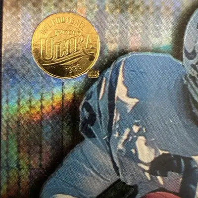 Gold-colored Fleer Ultra Marshall Faulk trading card with holographic light blue pulsar design
