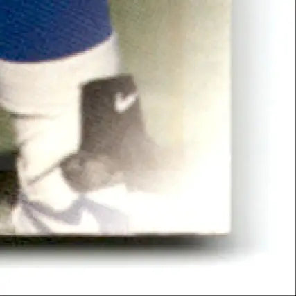 Person’s leg in black Nike shoe with white swoosh, blue shorts, for leaf football Darren Woodson #126 Dallas Cowboys