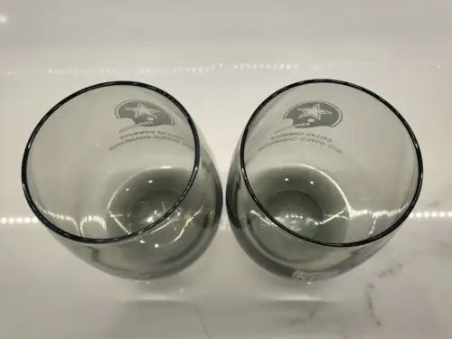 Two smoke gray stemless wine glasses featuring Dallas Cowboys 1972 WORLD CHAMPIONS design