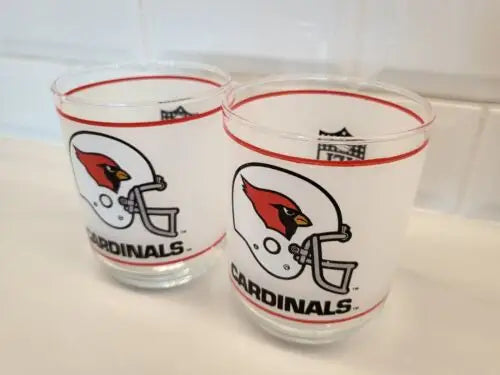 Two vintage NFL Mobil glasses featuring the iconic Louis Cardinals logo