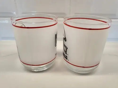 Two frosted glasses with red trim featuring Vintage NFL Mobil Louis Cardinals design