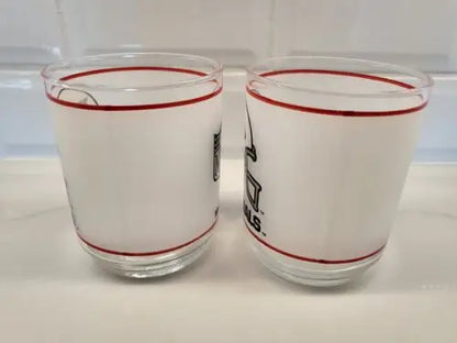 Two frosted glasses with red trim featuring Vintage NFL Mobil Louis Cardinals design