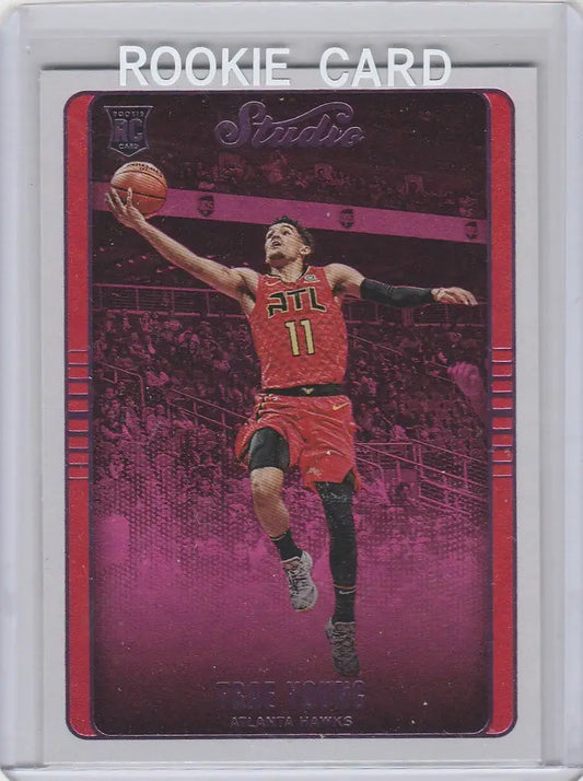 Basketball rookie card of Trae Young laying up in red jersey number 11 from Chronicles Trae