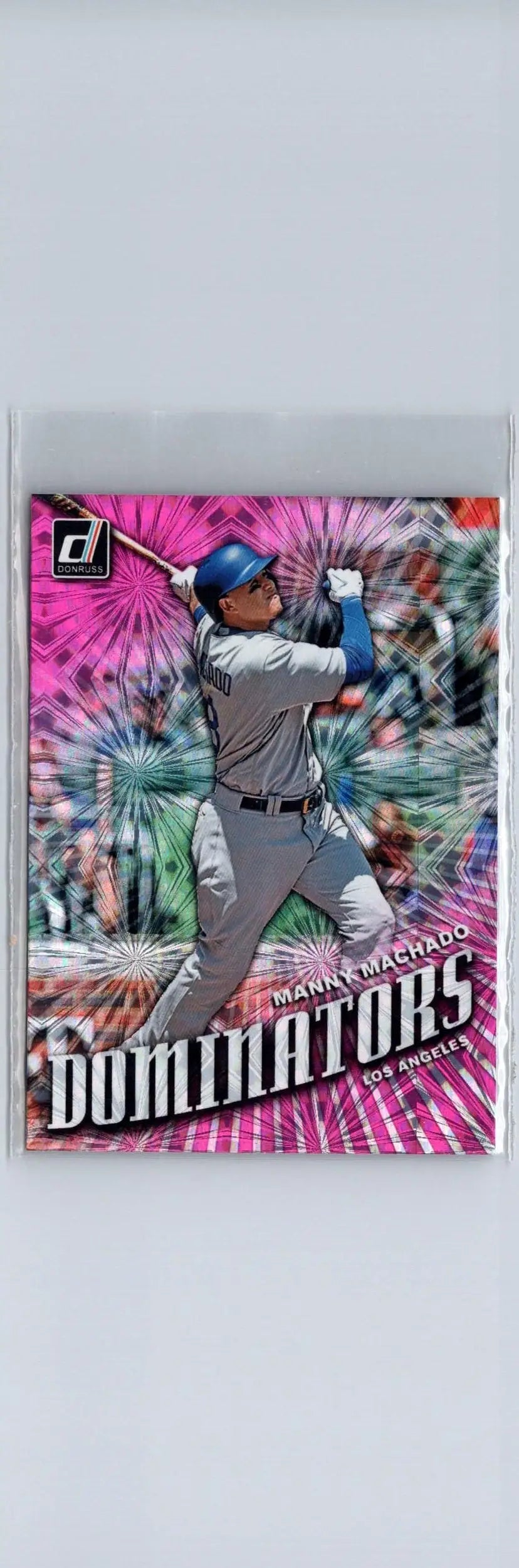 Manny Machado Dominators pink baseball card with player swinging bat against colorful background