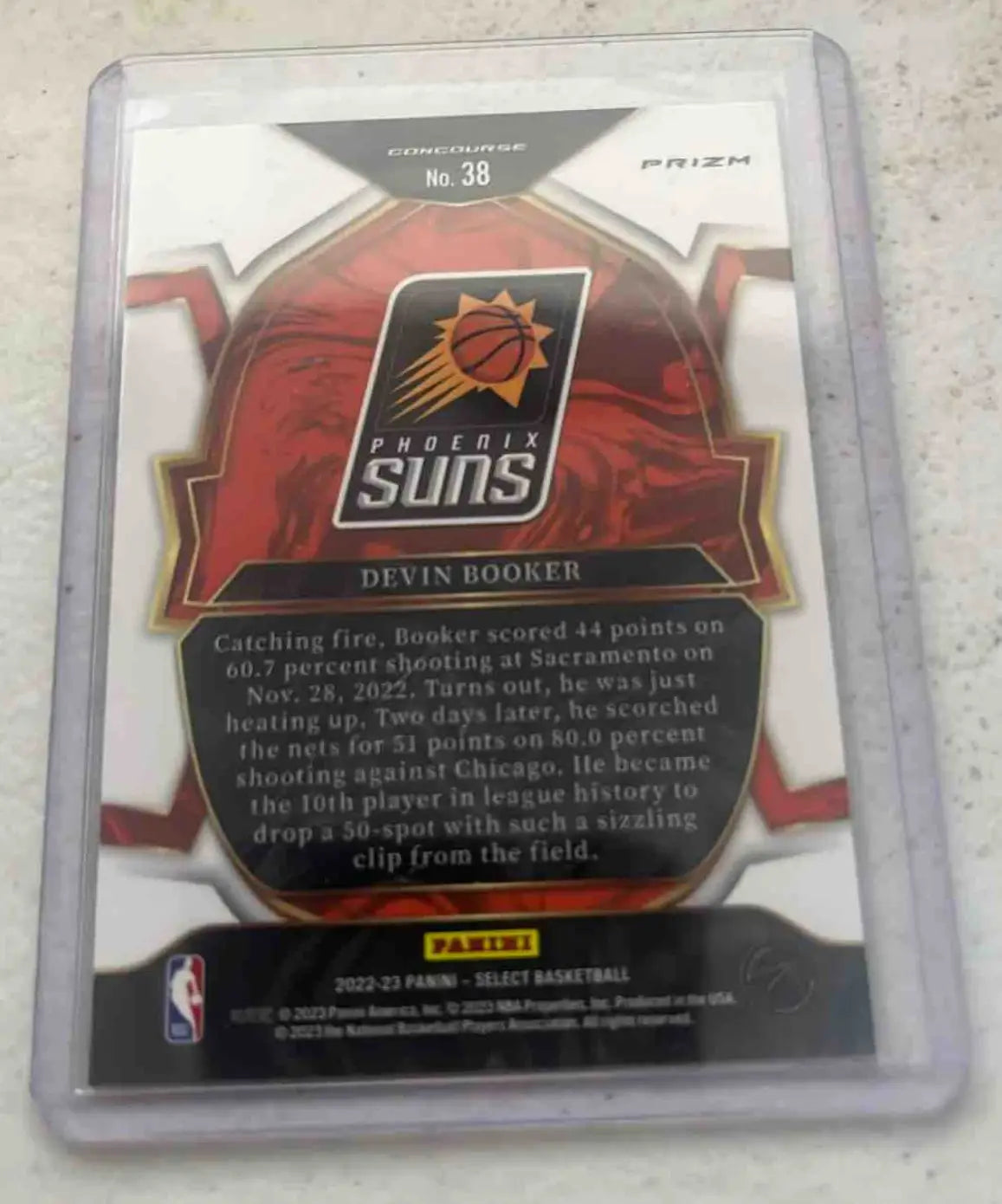 Devin Booker Phoenix Suns Panini Select Devin trading card in protective sleeve featuring Devin Booker Green design