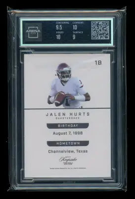 A graded Jalen Hurts Signature Keepsake Football in a clear slab from the Football Edition Orange series