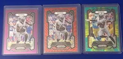Three graded football trading cards from the 2023 Josh Jacobs Devante Adams Prizm Lot