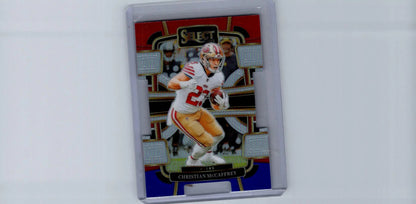 Football trading card of Christian McCaffrey in protective case from 2023 Panini Select featuring Black and Red Prizms Die Cuts