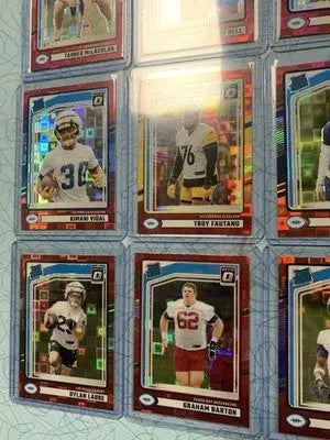 Football trading cards in protective cases from 2024 Donruss Optic Red Pandora Red Pandora Rated Rookie Card Lot