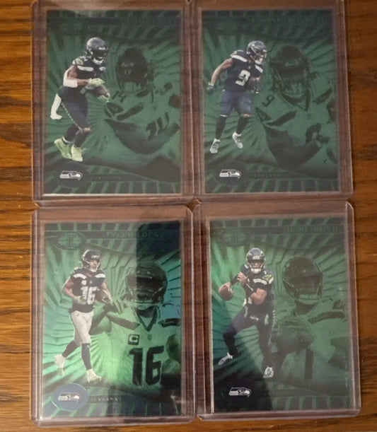 Four Seattle Seahawks trading cards in protective cases from 2024 Illusions Emerald Green series
