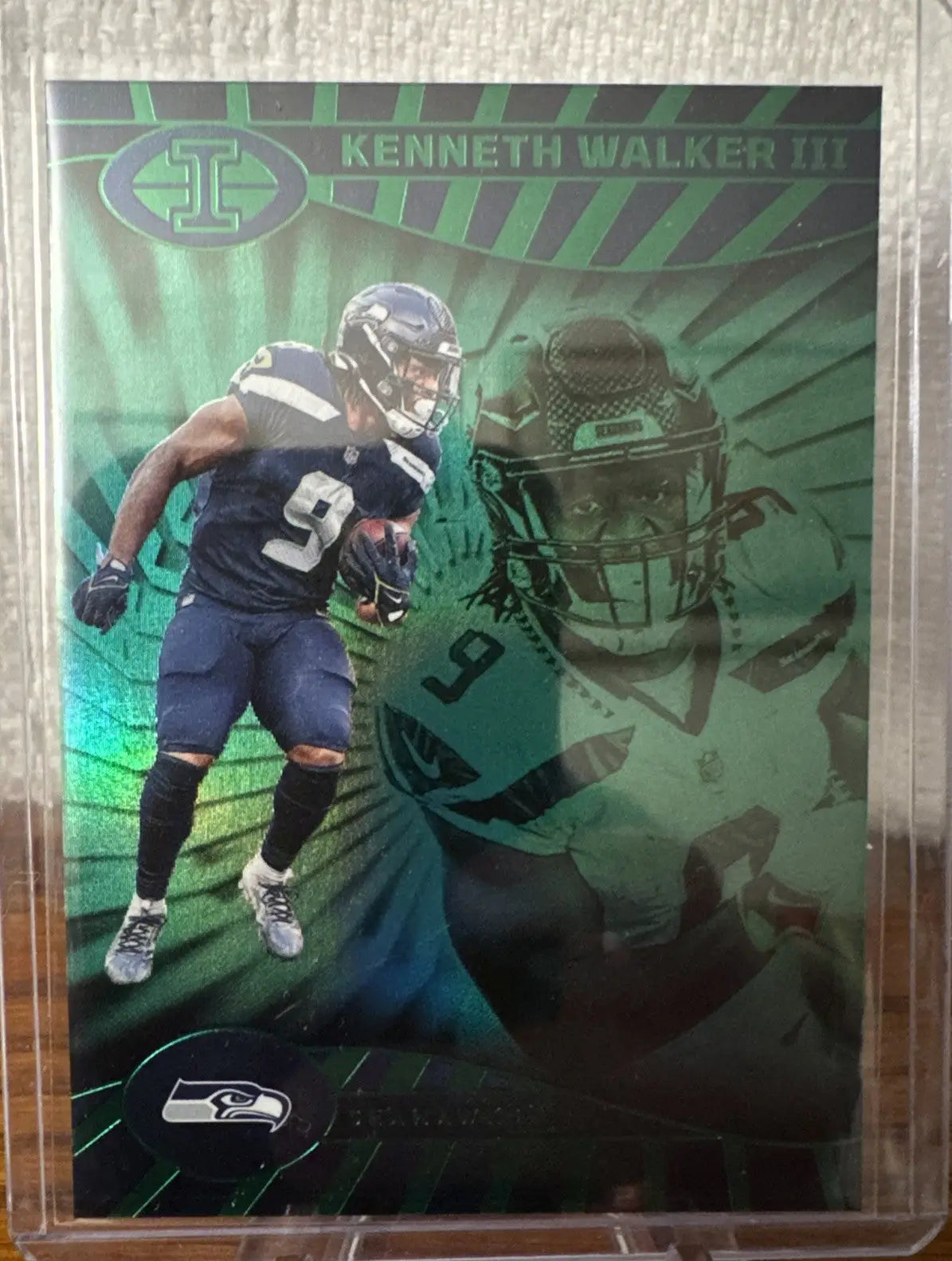 Football trading card of Kenneth Walker III in a protective sleeve from Illusions Emerald Green Seahawks lot