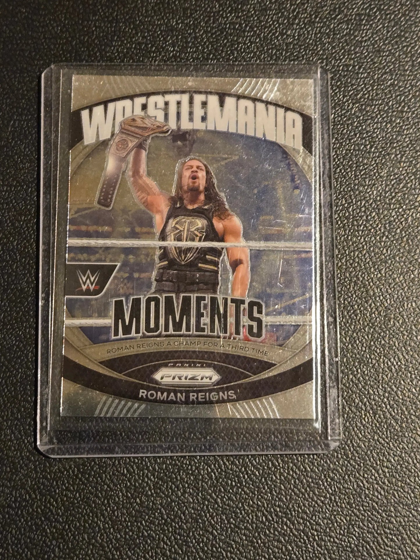 Roman Reigns Panini Prizm WWE WrestleMania Moments trading card in protective sleeve