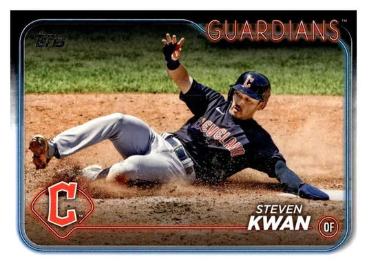 Cleveland Guardians player Steven Kwan slides on dirt in a baseball game action shot