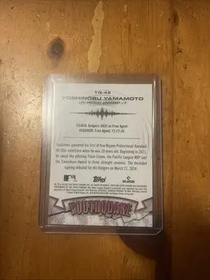 Baseball card of Yoshinobu Yamamoto in protective case from 2025 Topps Chrome Yoshinobu YouthQuake Gold Refractor