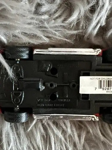 Underside of black diecast car with silver side exhaust pipes from diecast car collection