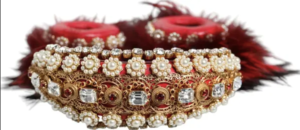 Gold and pearl jewelry set with red flowers in the background