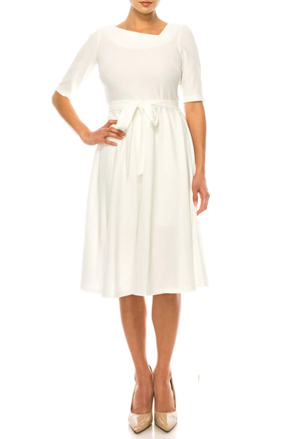 Woman modeling Maison Tara day dress in ivory or azure blue with boat neck and tie waist