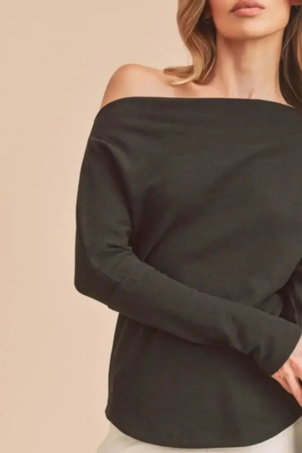 Black off-the-shoulder long sleeve knit top from Aemi + Co featuring relaxed fit