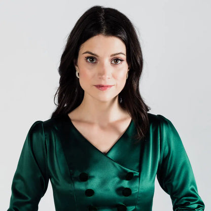 Woman in emerald green poly satin Paris Bloom Noel uniformed party dress with V-neck