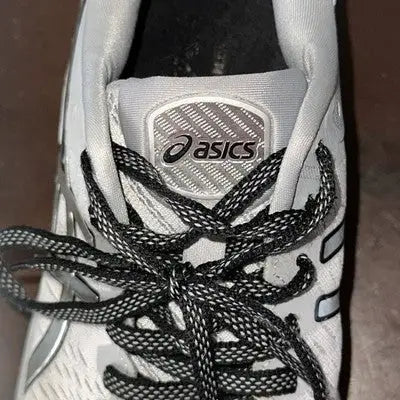 White Asics athletic running shoes with black and white speckled laces for women