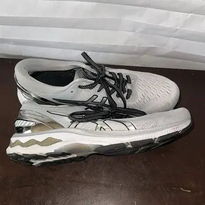Pair of light-colored Asics running shoes with black laces for women size 9.5