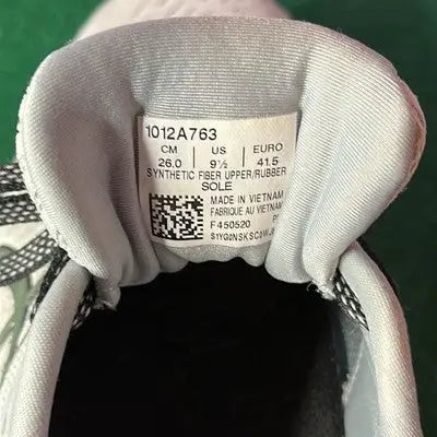 Inside tag of Asics Pale Gray Low Top Sneakers showing size info and manufacturing details for running shoes