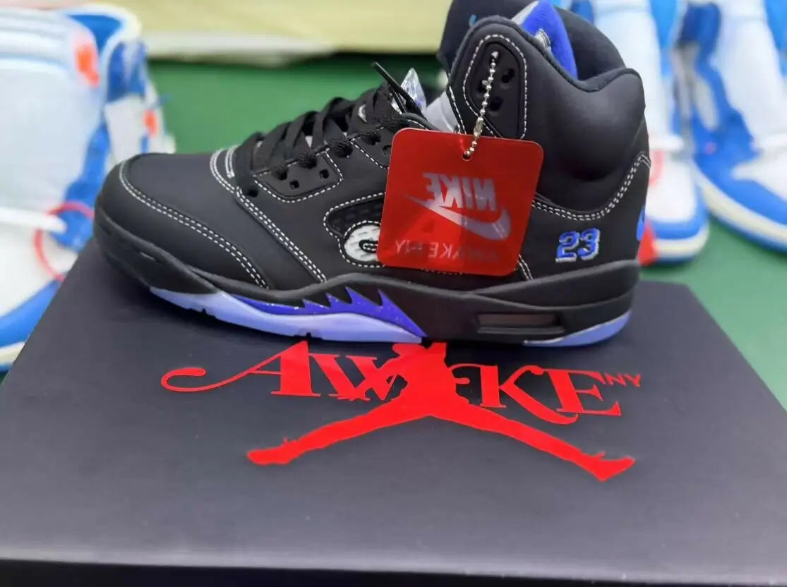 Black Air Jordan 5 sneaker with blue accents and Awake NY logo, fast shipping available
