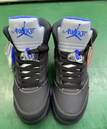 Black and gray Air Jordan 5 sneakers with blue accents from Awake NY x Air Jordan 5 for fast shipping