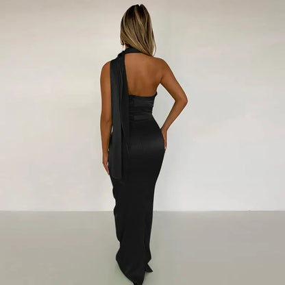 Woman in black satin backless maxi dress with sash detail, perfect for elegant occasions