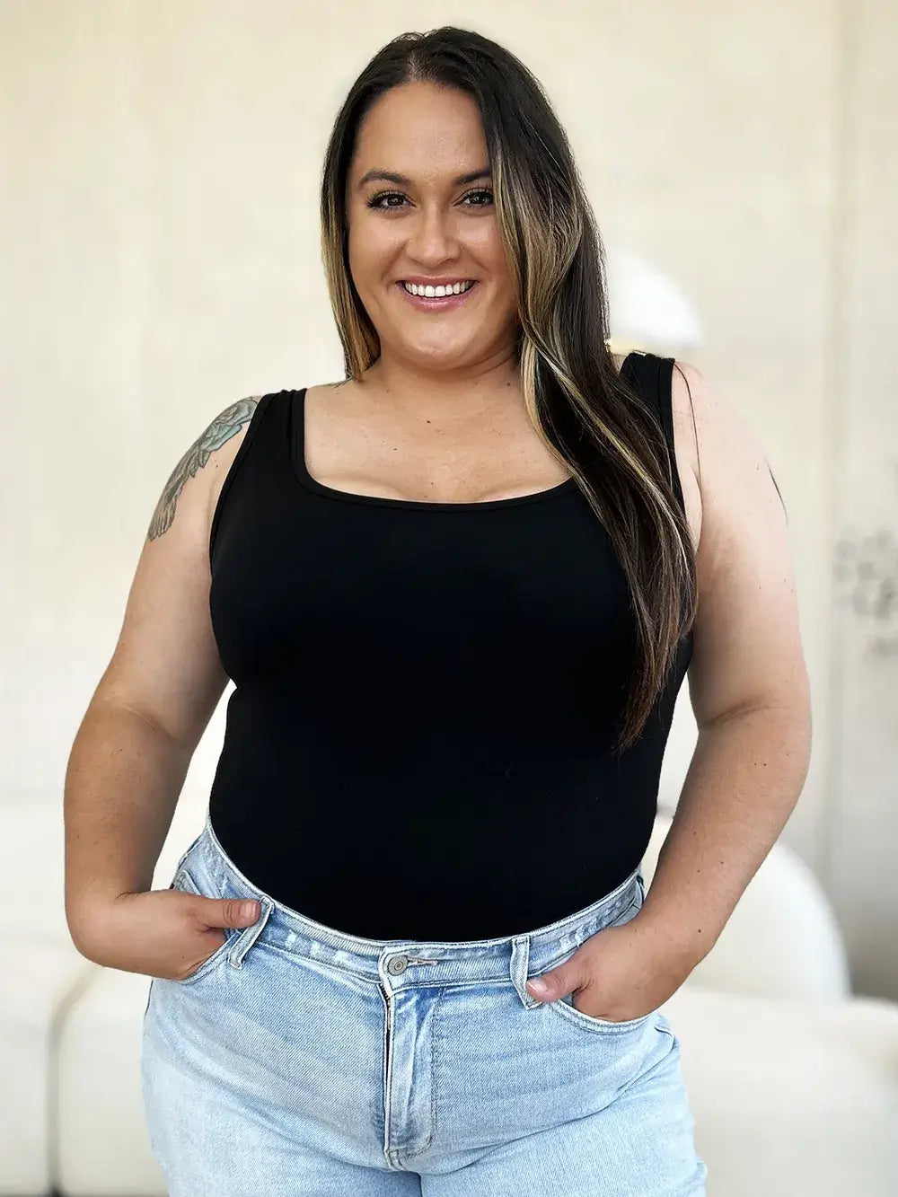 Plus-size woman in black tank top and light-wash jeans showcasing Basic Bae square neck sleeveless bodysuit