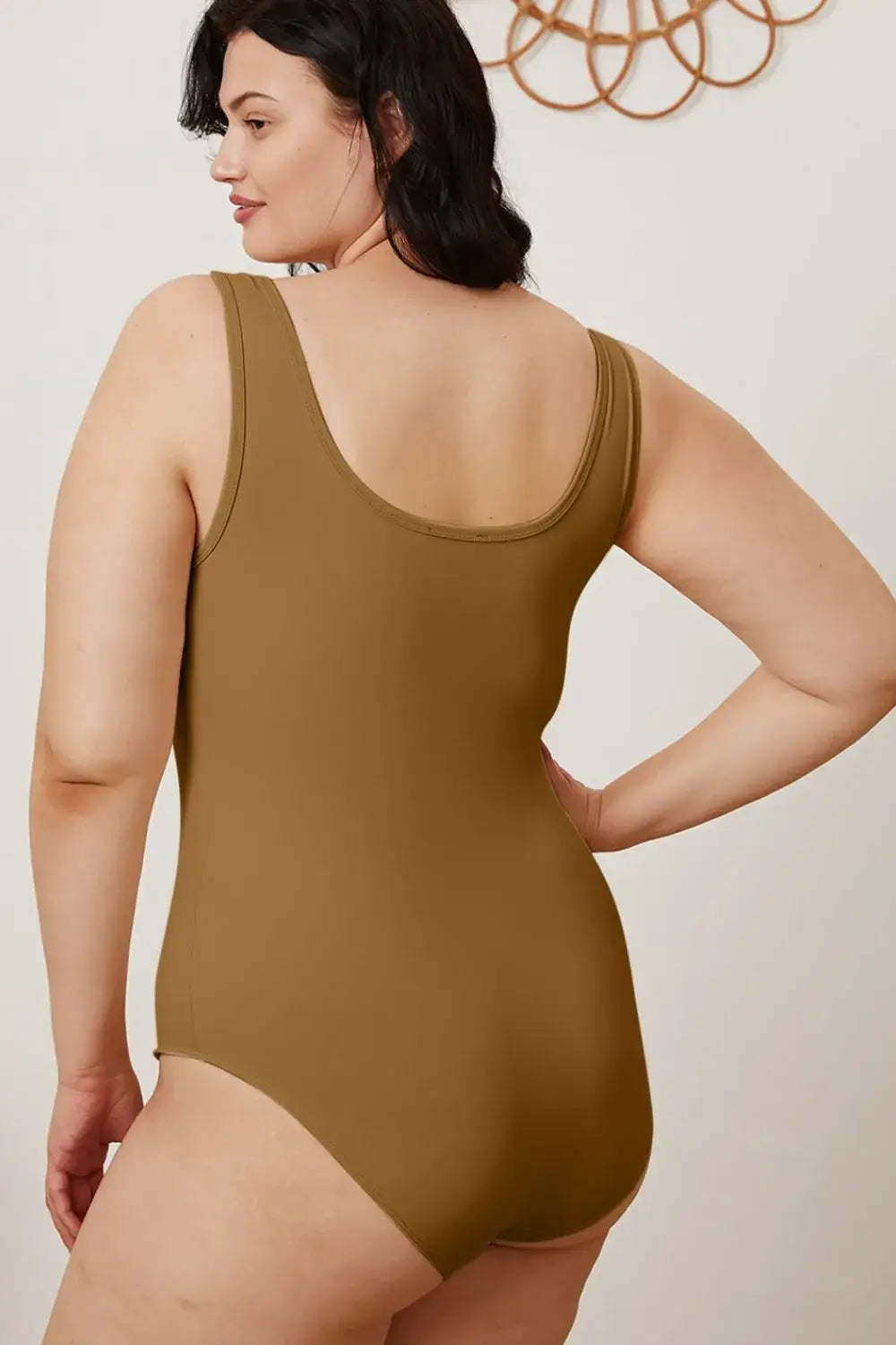 Plus-size woman in brown square neck sleeveless bodysuit, perfect for jeans size 16