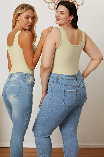Two women modeling light wash distressed high-waisted jeans with a Basic Bae square neck sleeveless bodysuit