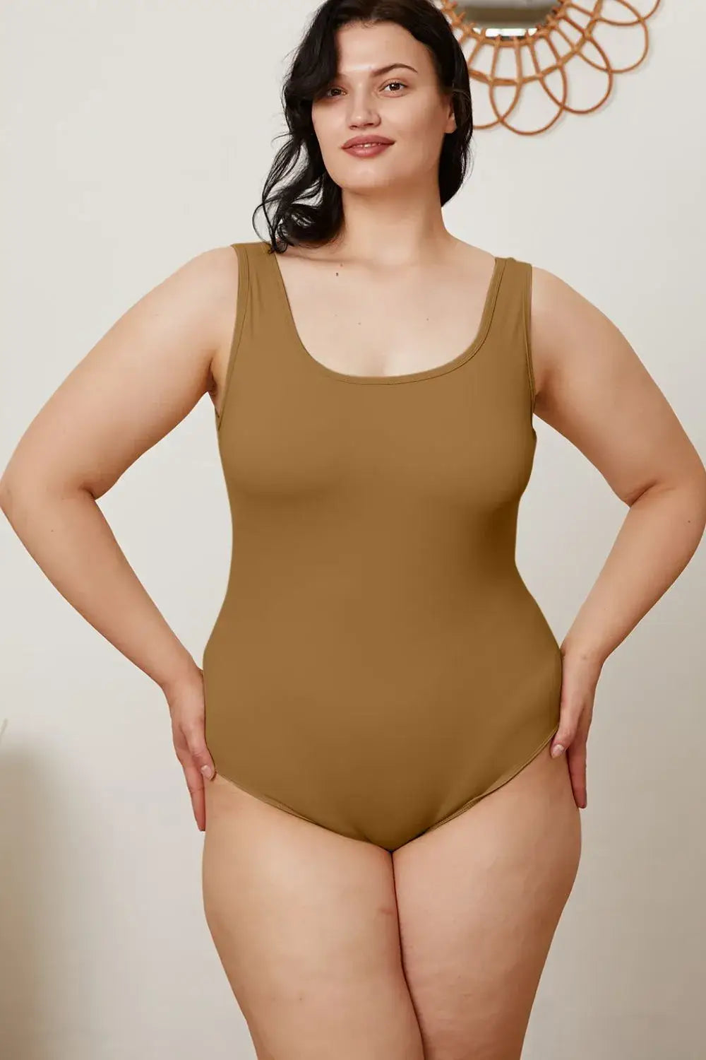 Woman in solid brown square neck sleeveless bodysuit, perfect for jeans size selection